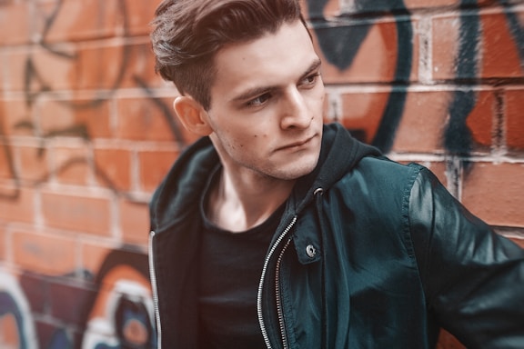 man standing against brown wall