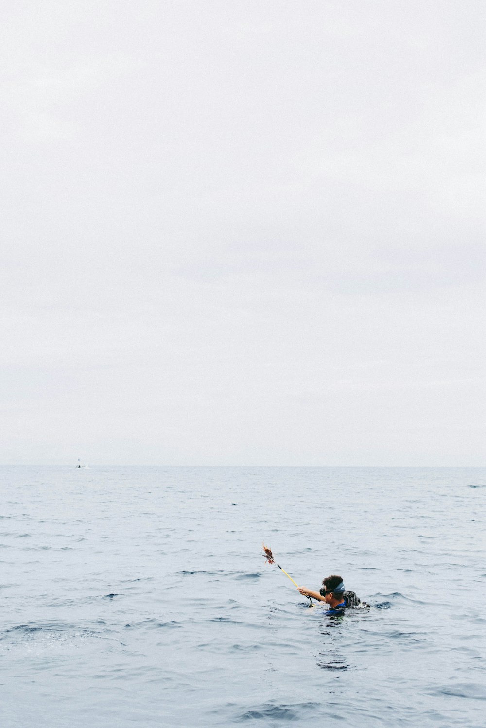 man holding rod while on water