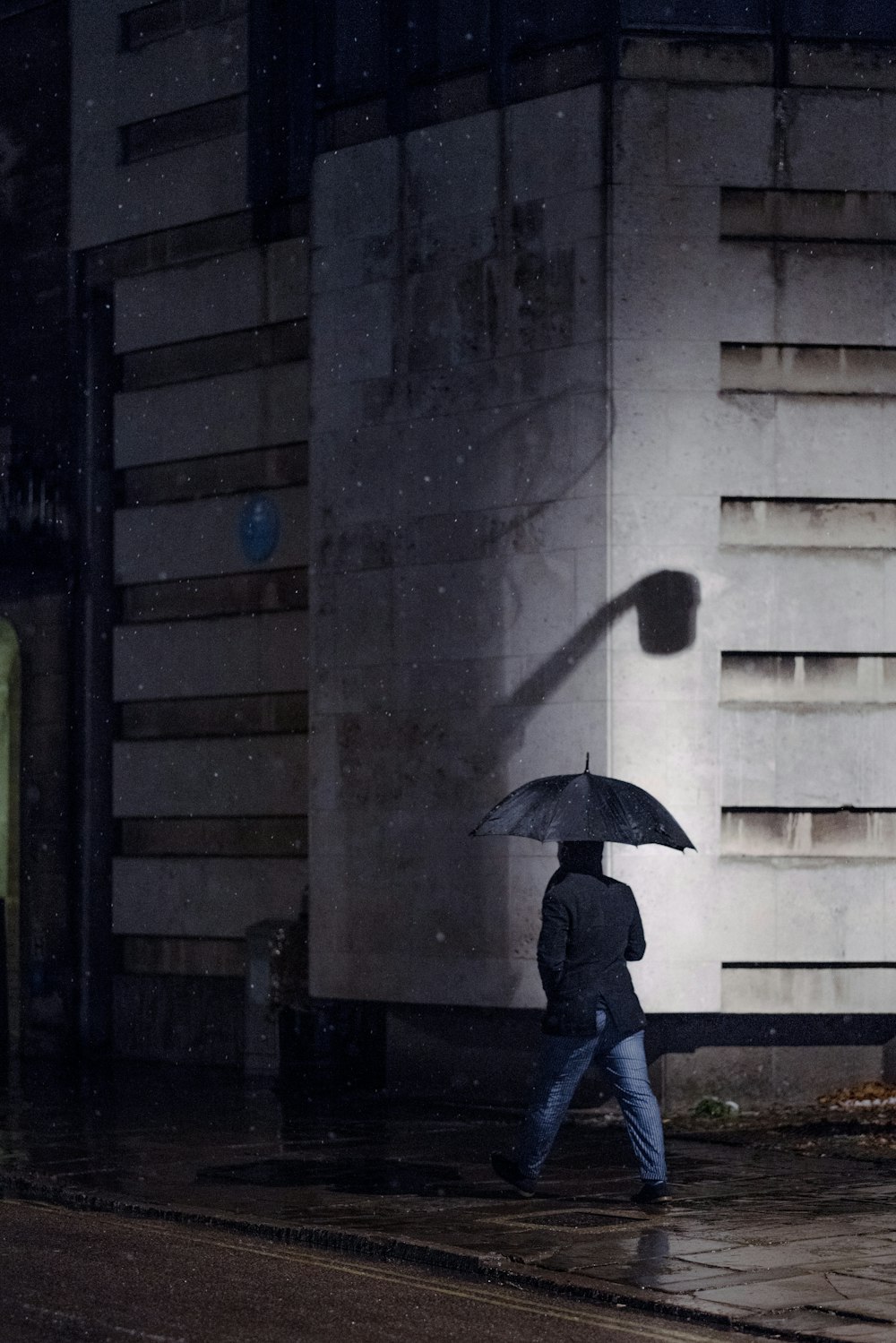 우산 아래를 걷는 남자