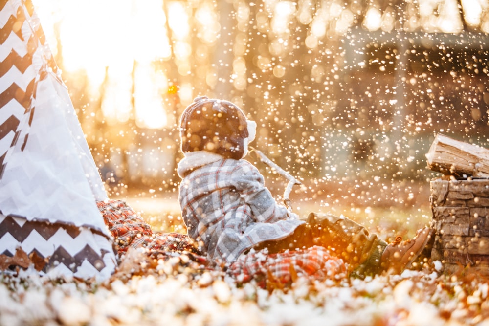 Photographie sélective de l’enfant assis sur le sol