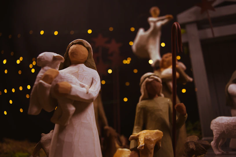 A detailed handcrafted nativity scene with wooden figurines and soft glowing lights.