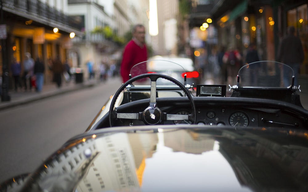 black convertible in front of standing man during daytime