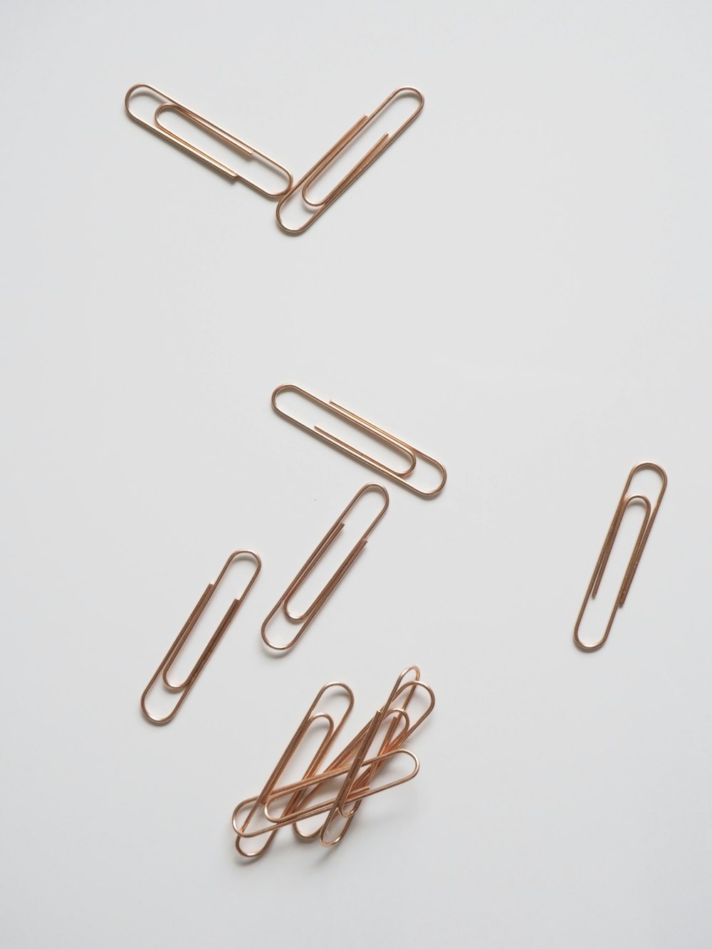 brown paper clips on white surface