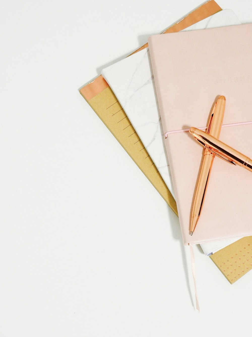 Kugelschreiber auf rosa Notizbuch