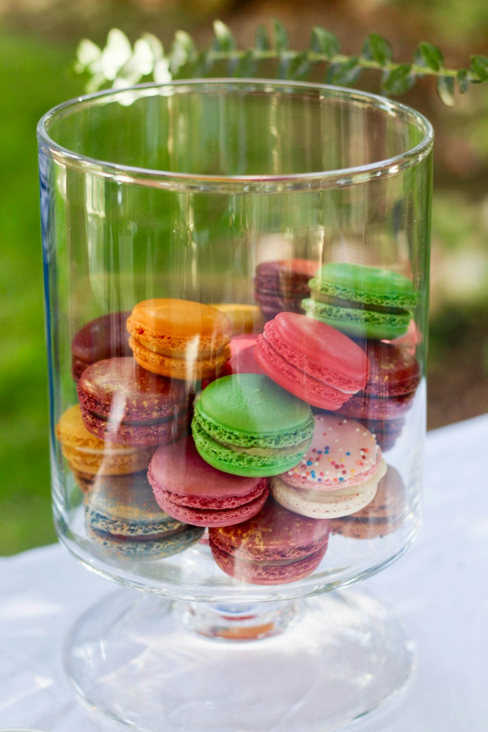 French macaroons inside clear glass container on top of table