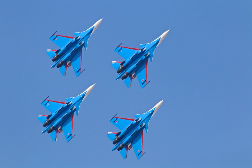 Cuatro aviones de combate azules bajo el cielo azul