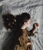 woman in brown long-sleeved top sleeping on bed