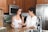 A happy customer discussing service with a technician in a kitchen.