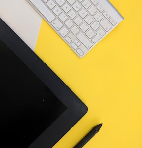 gray Apple wireless keyboard beside black tablet computer and stylus pen