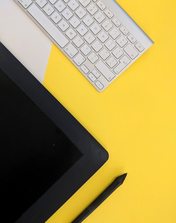 gray Apple wireless keyboard beside black tablet computer and stylus pen