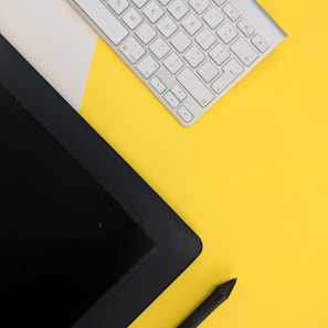 gray Apple wireless keyboard beside black tablet computer and stylus pen