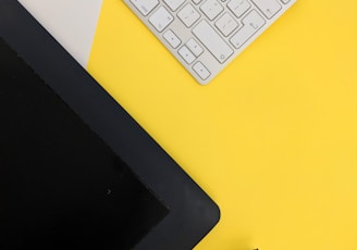 gray Apple wireless keyboard beside black tablet computer and stylus pen