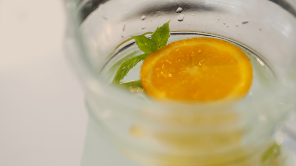 a glass filled with water and an orange slice