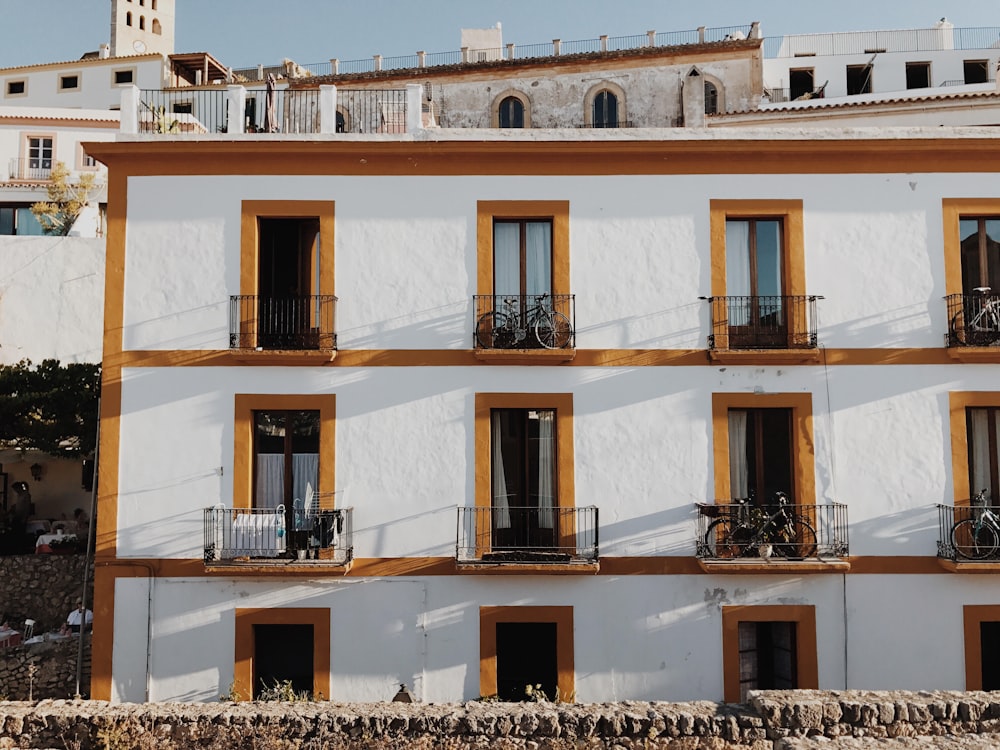 person standing under balcony with bicycle