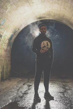 Dynamic shot of a footballer mid-dribble under neon stadium lights.