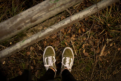 A pair of sturdy green running shoes on a trail path.