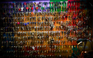 An array of colorful 3D printed keychains arranged neatly on a wooden surface.