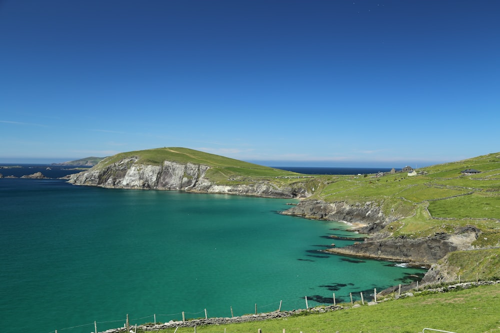 green grass field near calm body of water