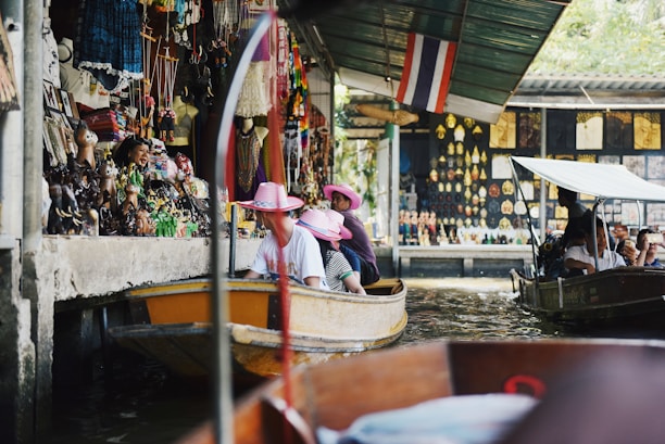 A vibrant group of travelers enjoying a guided tour in a bustling Southeast Asian market.