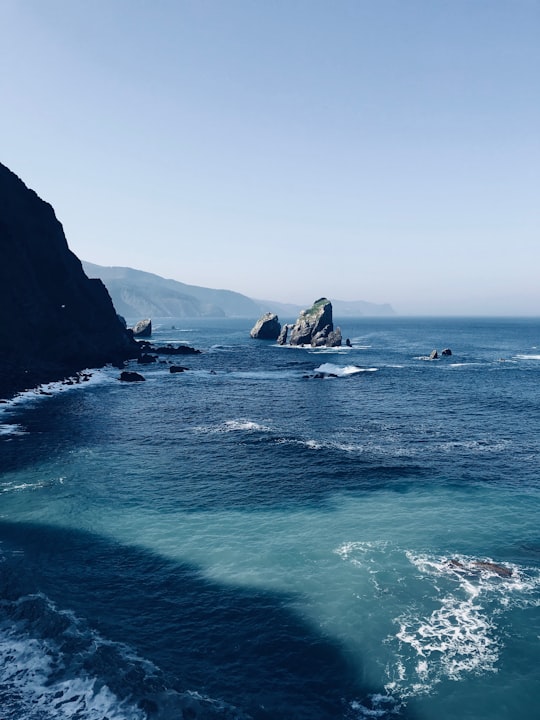 body of water near cliff in Escalinatas de San Juan de Gaztelugatxe Spain