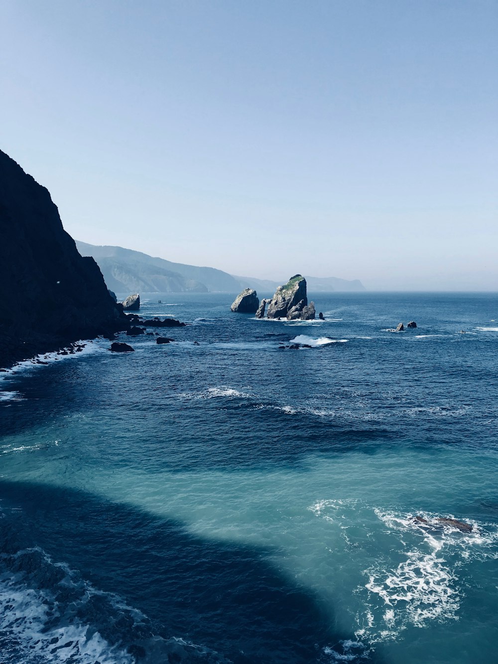 body of water near cliff