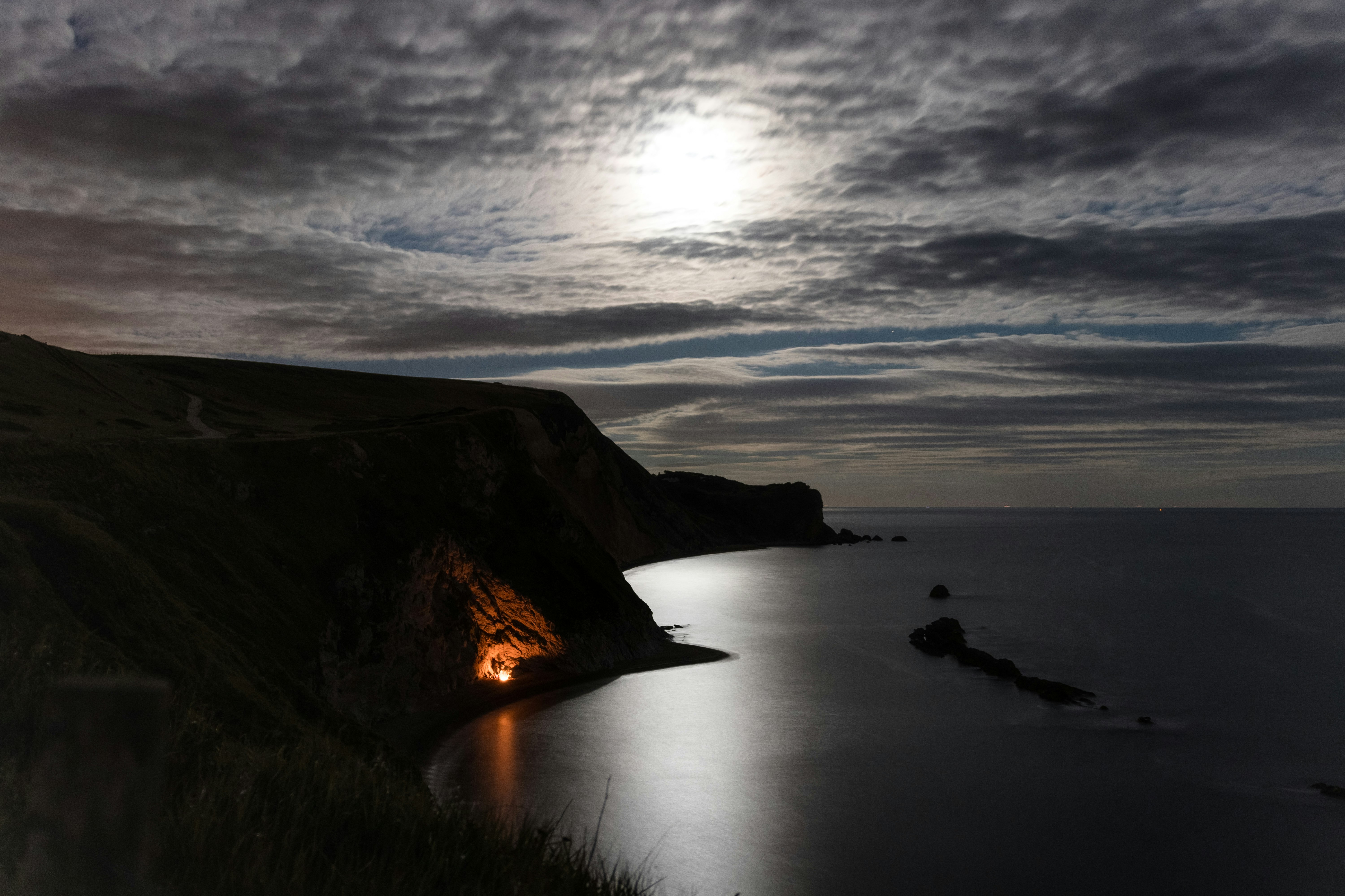 landscape photography of cliff under gray sky at nighttime