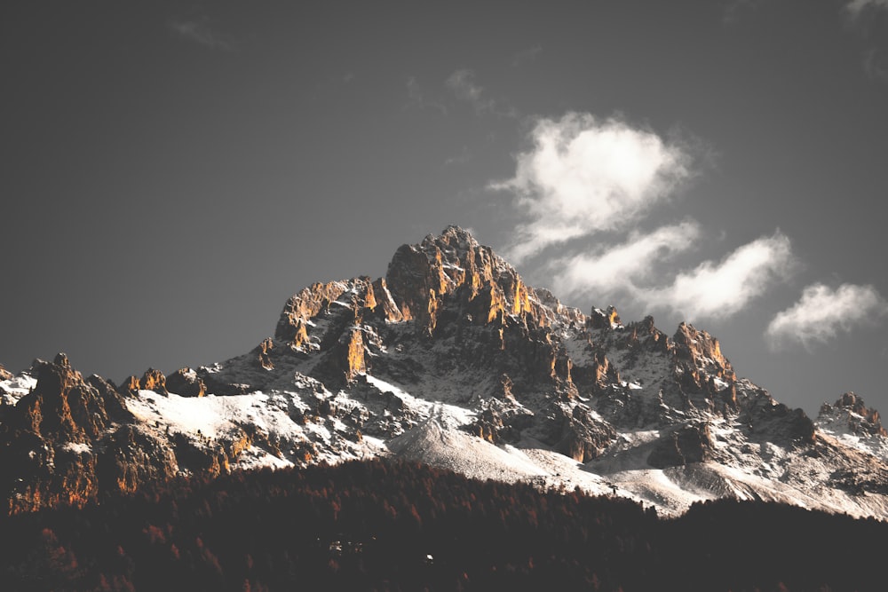 snow-covered mountain under cloudy sky during daytime