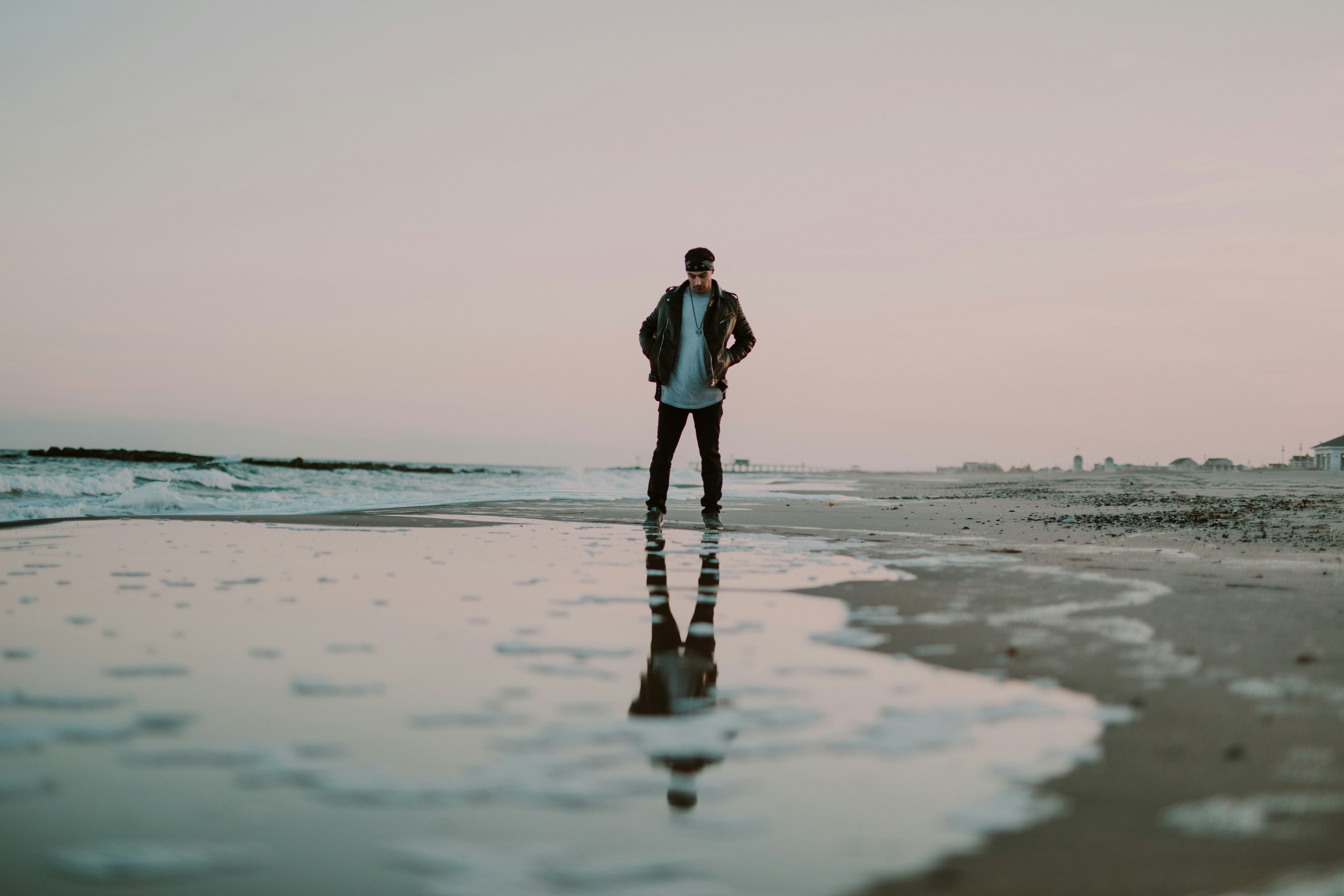 photography of man standing near water body