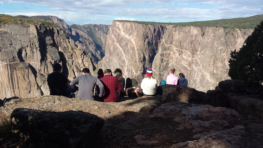 group of people sitting on cliff