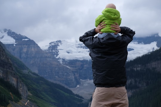 person carrying baby on his neck overlooking mountain in Banff National Park Canada