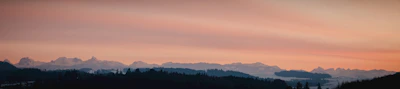 A panoramic shot of a bear silhouetted against a fiery sunset sky.