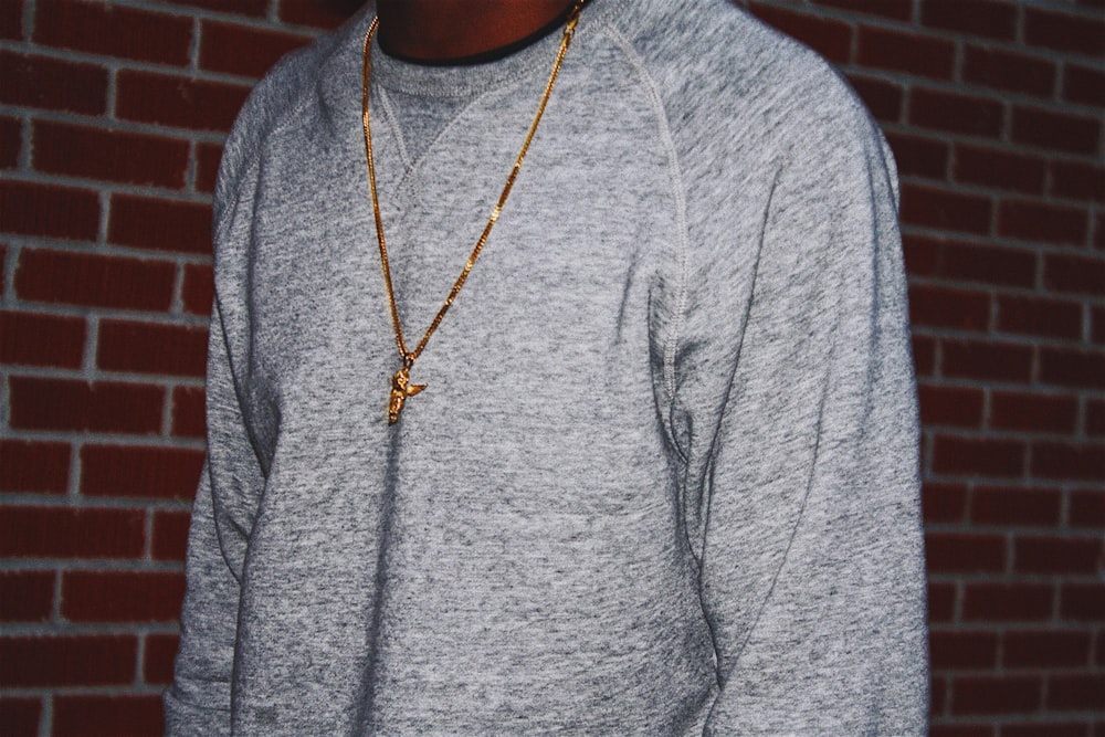 person standing wearing gold-colored necklace