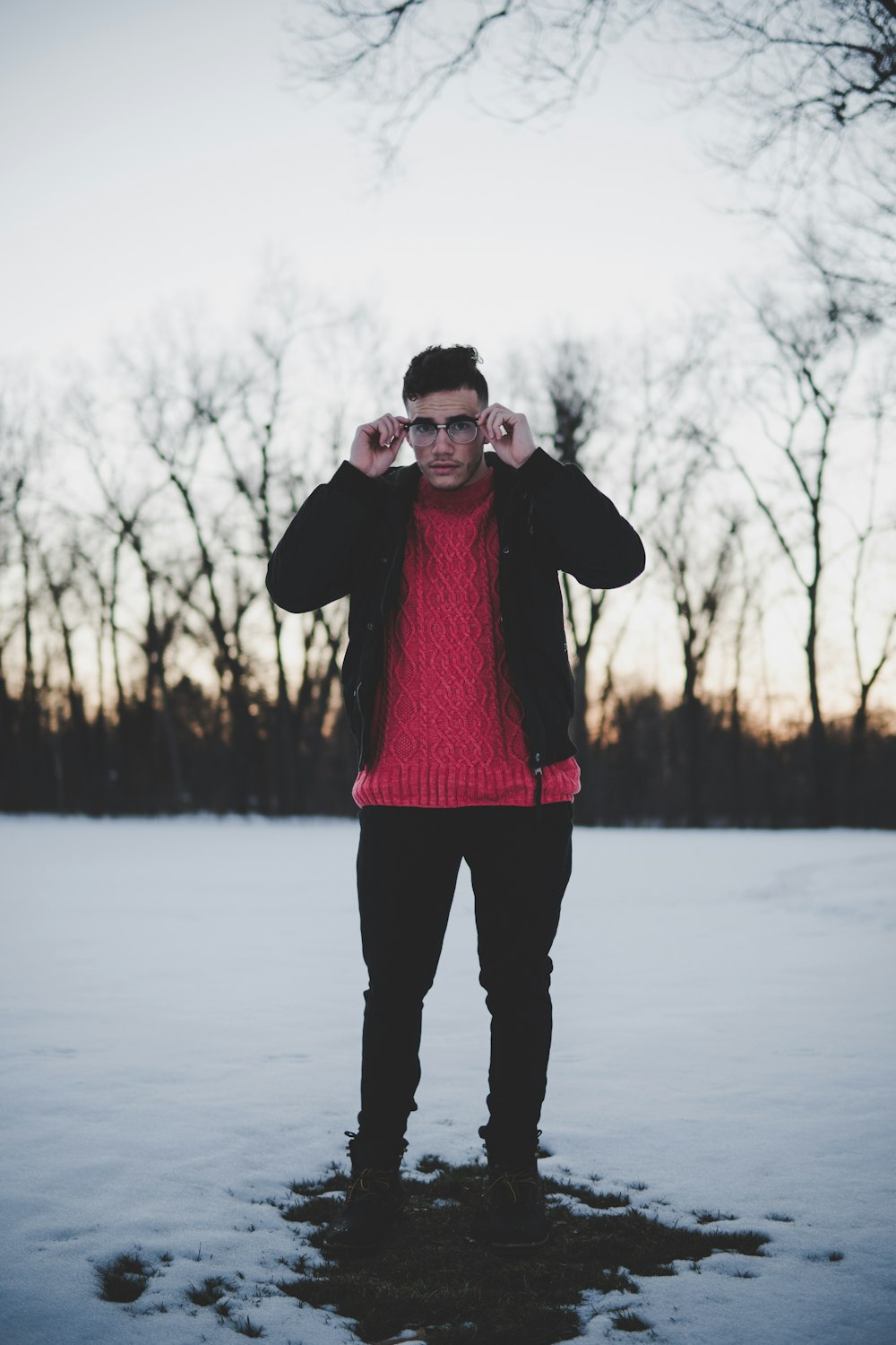 man standing holding his eyeglasses