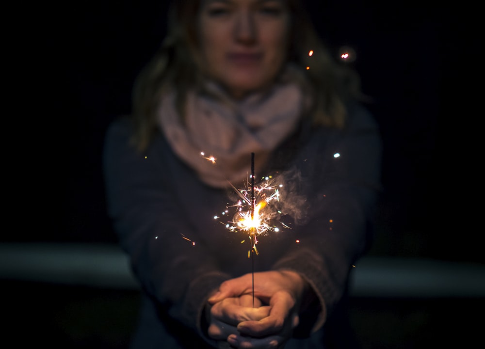 Frau mit Wunderkerze in der Nacht