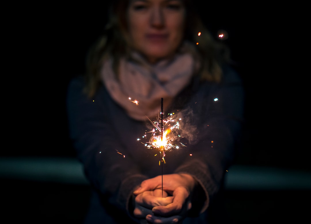 woman holding sparkler during night