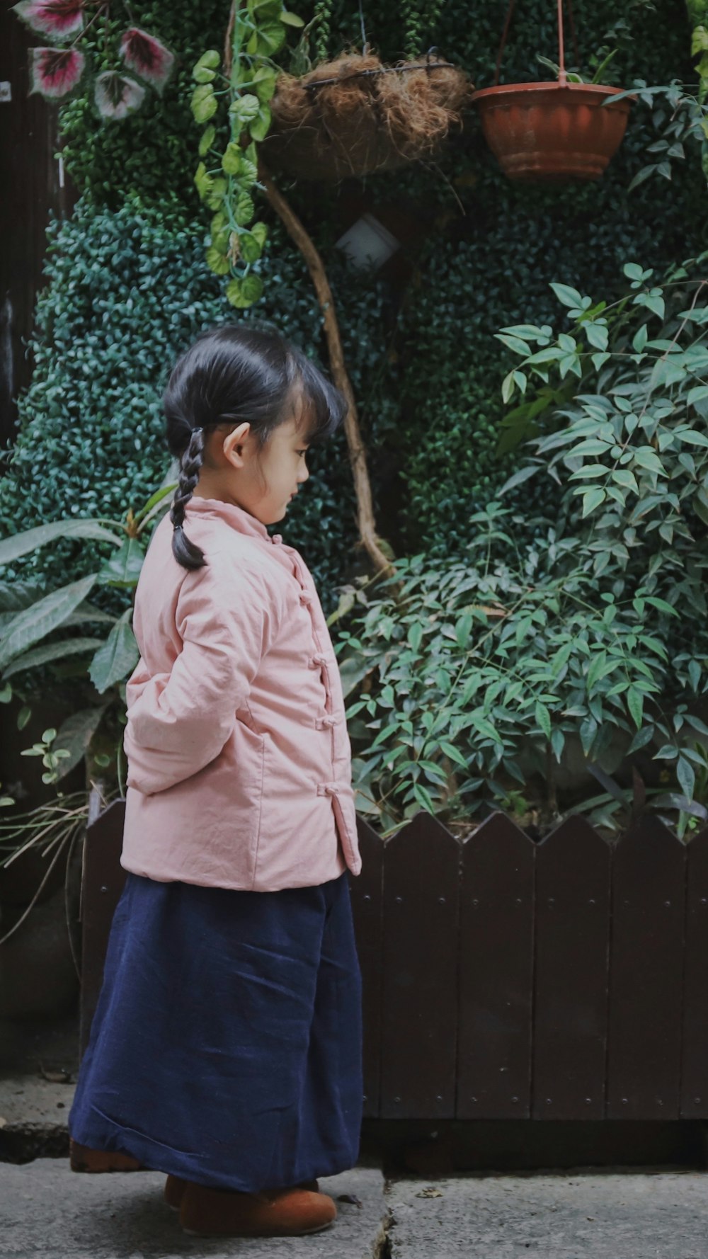 girl standing in front of garden