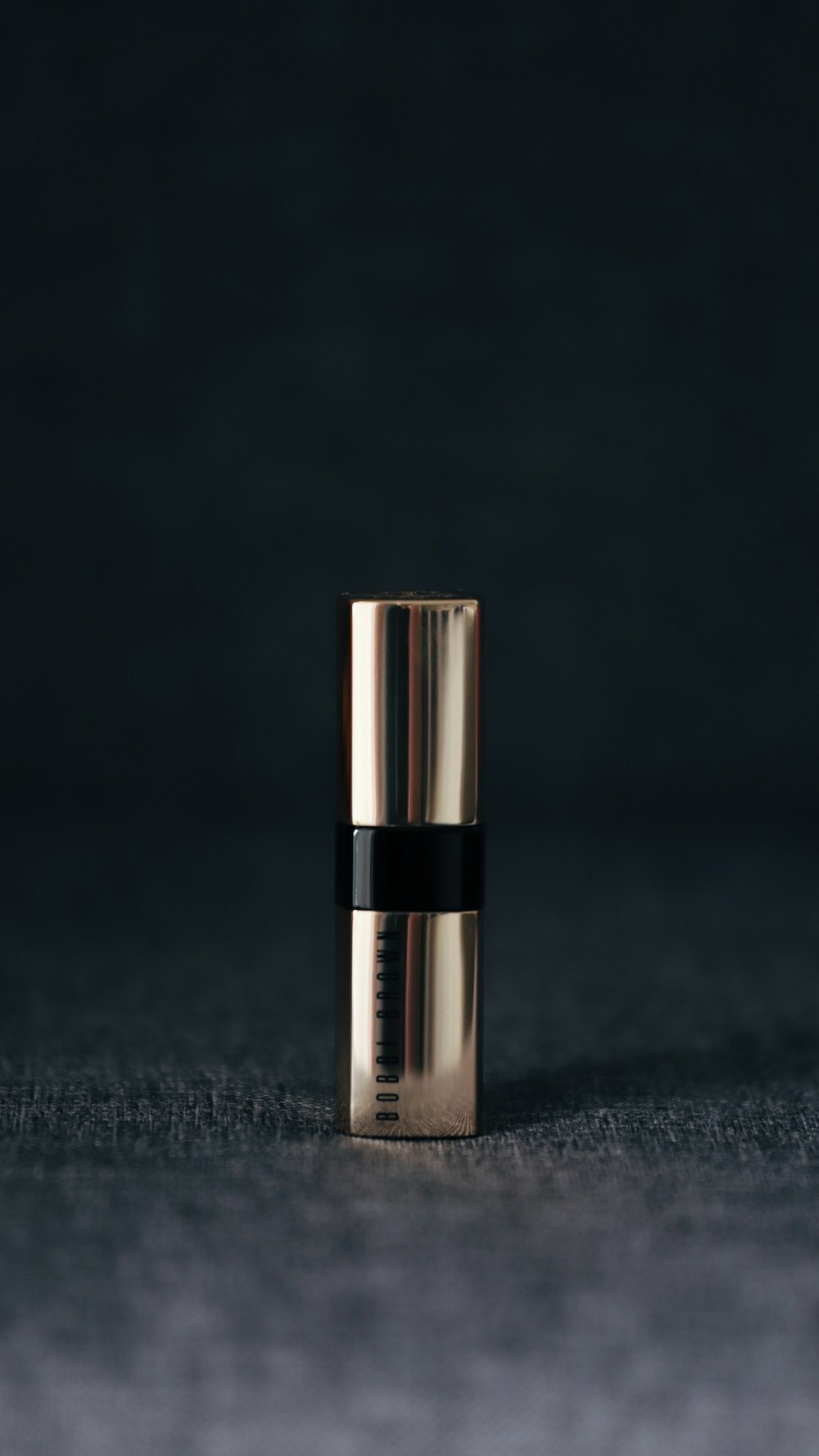 grey lipstick container in selective focus photography