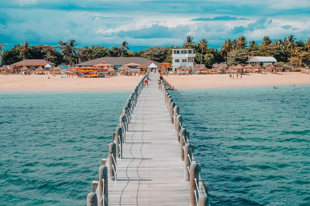 photo of brown wooden dock towards beach