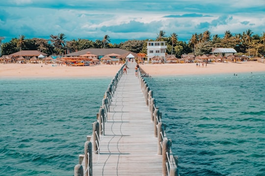 photo of brown wooden dock towards beach in Lakawon Island Resort Philippines