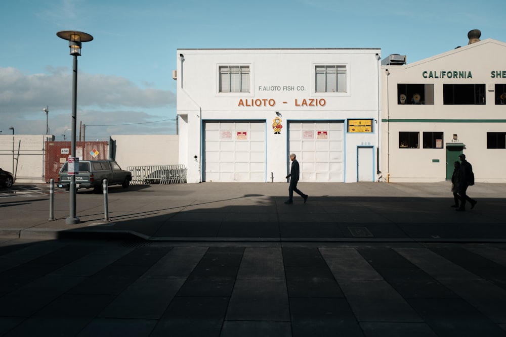 man walking in front of Alioto Lazio building