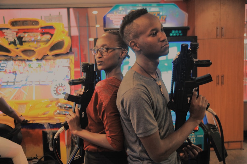 man and woman holding assault rifle arcade controller