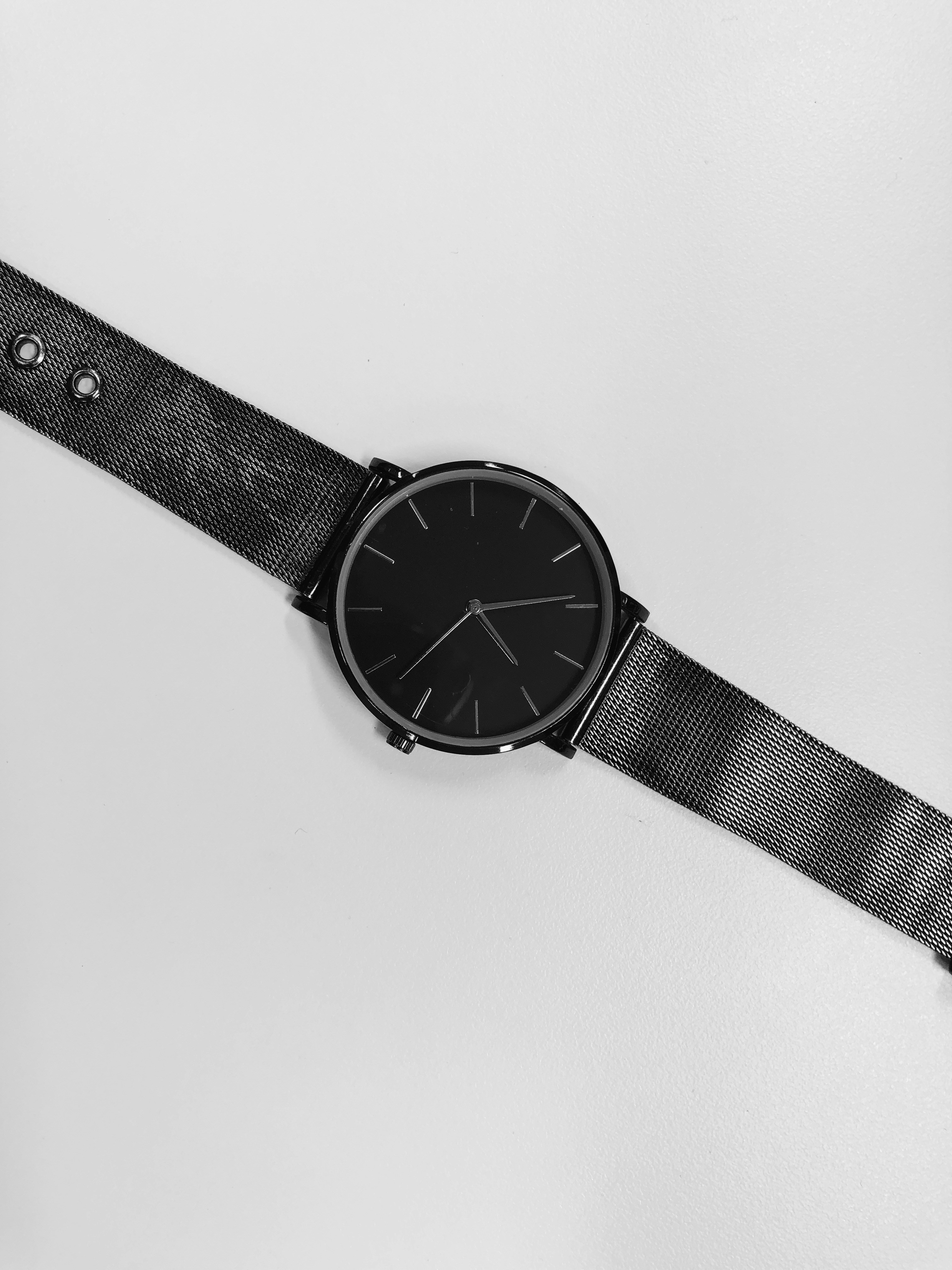 Minimalist watch brand ad with clean white background and premium serif typography