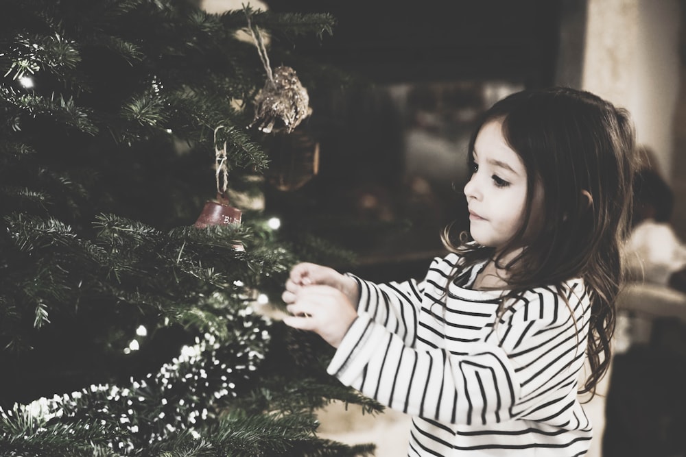 chica decorando el árbol de navidad