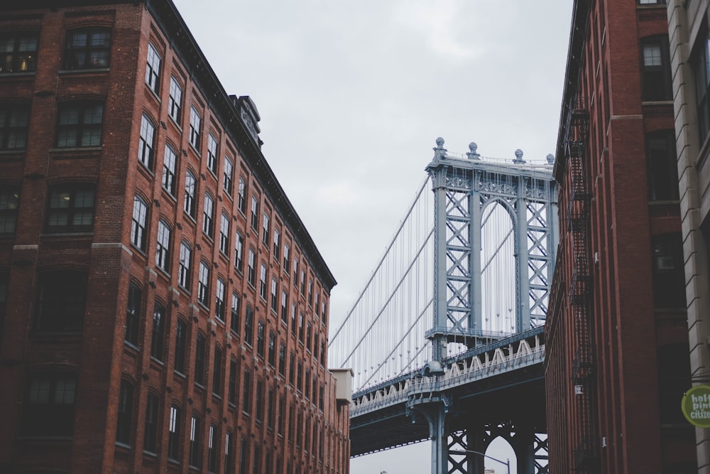 Fotografia de arquitetura de ponte cinza e edifício marrom