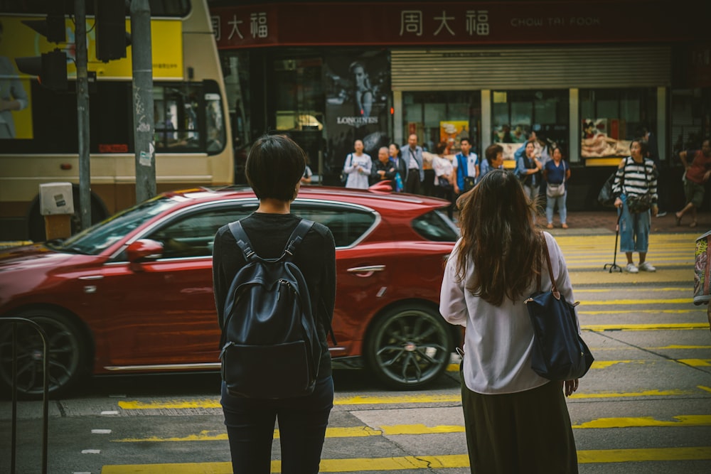 빨간 차 근처에 서 있는 남자와 여자