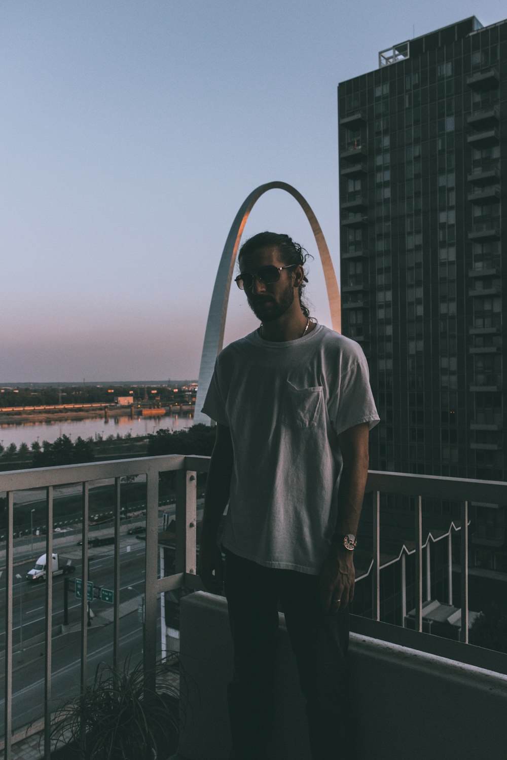 man standing behind handrails