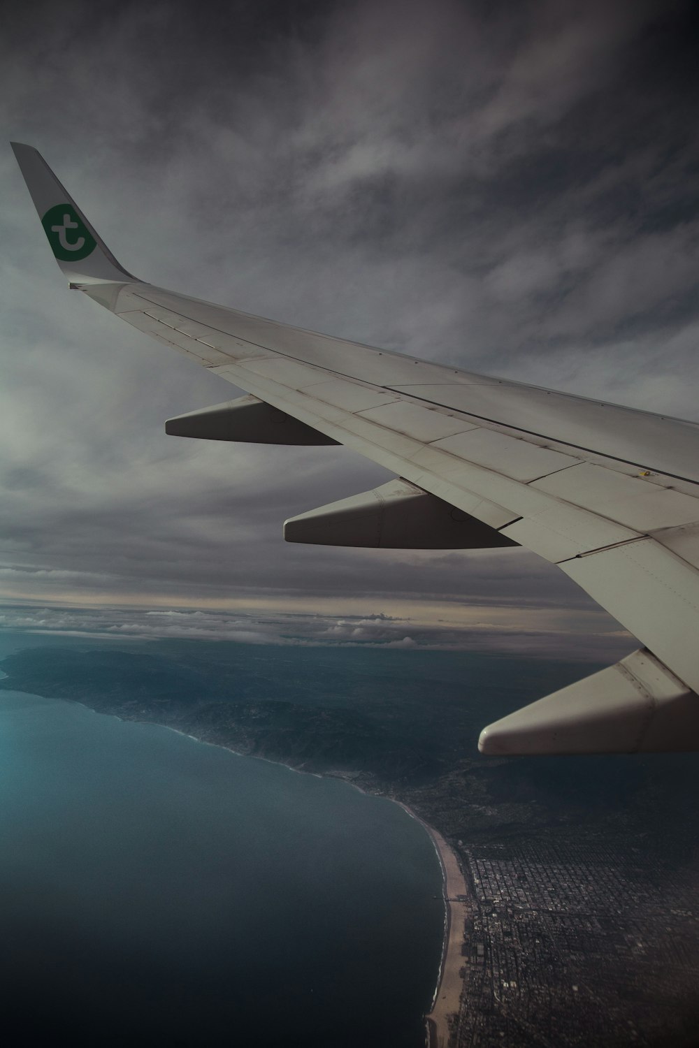 aerial photography of plane wing and body of water