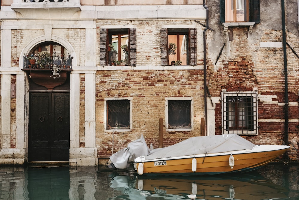 orange boat in front of building