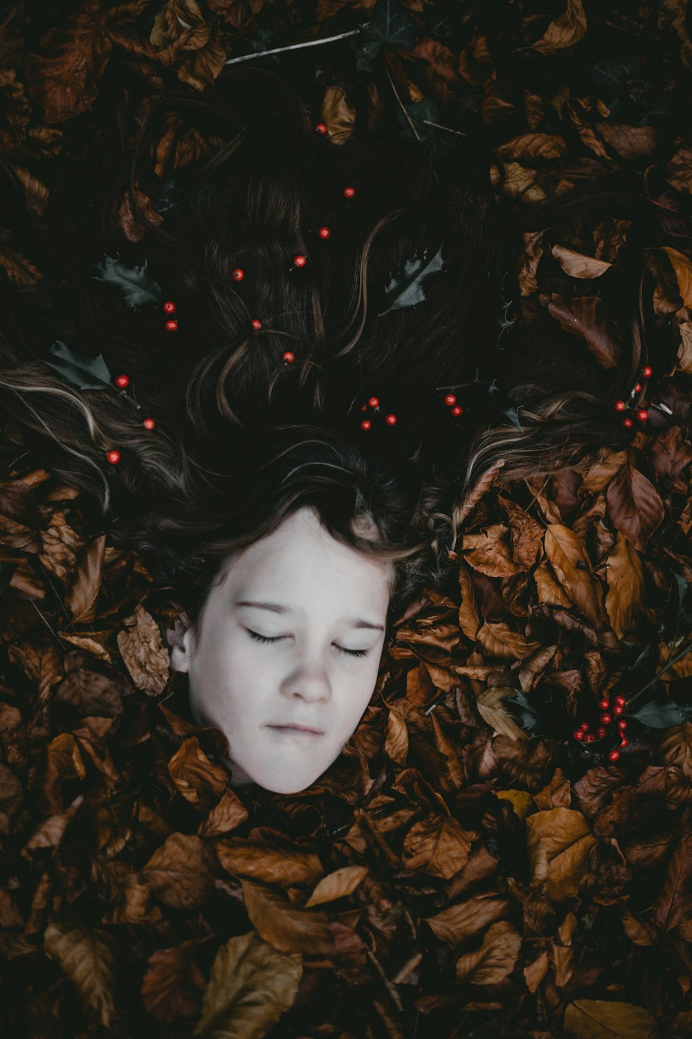 girl covered by leaves