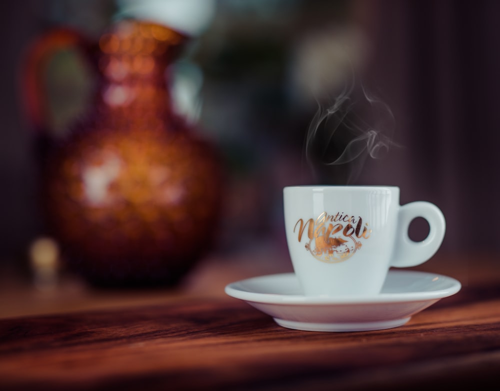 Flachfokusfotografie einer Teetasse aus weißer Keramik
